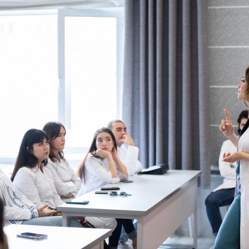 A surgical education instructor delivering a lecture performance breakdown to medical candidates.